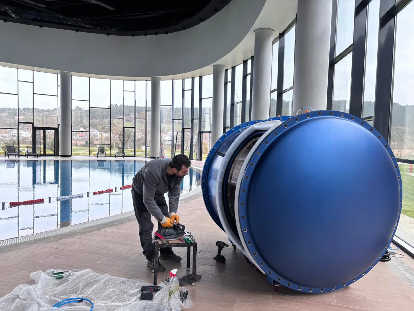 Oxyliving technician assembling the chamber beside the pool